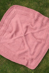 Overhead shot of pink blanket on grass. thumbnail
