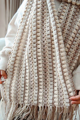 Woman holds scarf toward camera, showing fringe. thumbnail