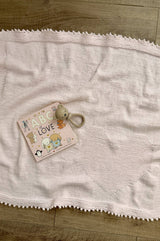Full view of pale pink knit blanket, showing heart in lower right corner and a picot edge all around. thumbnail