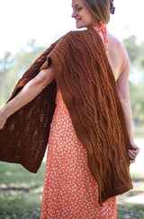 Woman wears rectangular wrap draped over one shoulder. The wrap comes down to mid-thigh in both front and back. thumbnail