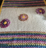 Close up of textured stitch used in blanket and 3-D applied flowers. thumbnail