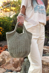 Back view of tote bag, showing open lattice bag body, with solid top and bottom, and short handles. thumbnail