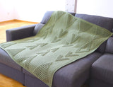 Crochet blanket is laid out flat on grey couch. thumbnail