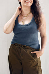 Front view of knit tank top in denim blue, worn with dark olive pants. It has a scooped neckline. thumbnail