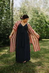 Front view of woman in a long dark dress wearing a crochet cardigan. thumbnail