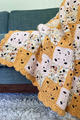 Close up of square motifs in blanket, and scalloped border. thumbnail