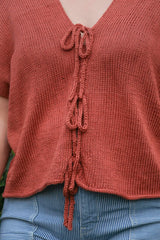 Close up of front of knit top, showing i-cord ties down the center front. thumbnail