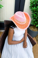 View of top of cowboy hat, showing shaped crown, lace pattern around hat bucket, braided trip, and shaped brim. The hat fades from pink to orange and back to pink. thumbnail