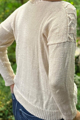 Back side view of knit cream sweater, showing plain back, drop shoulder, and ribbed hem and sleeve cuffs. thumbnail