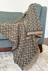 Close up of afghan draped over couch, showing ribbed edgings. thumbnail