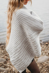 Woman wearing shawl on seashore thumbnail