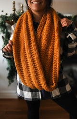 Woman wearing orange-yellow infinity scarf indoors thumbnail