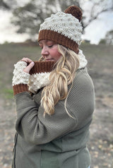 Woman facing left holds crochet cowl out, while wearing matching hat & mitts. thumbnail