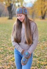 Woman with long hair wears crochet headband and mitts outdoors. thumbnail