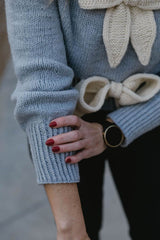 Close up of pale blue sweater cuff showing long wrist ribbing. thumbnail