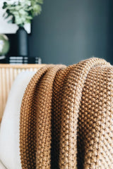 Knit throw draped over cream chair. thumbnail