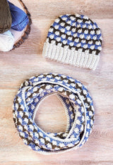 Crochet beanie and matching infinity scarf, coiled twice, on wooden backdrop.  thumbnail
