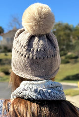 Back view of tan knit beanie with two rows of eyelets and coordinating faux fur pom pom.  thumbnail