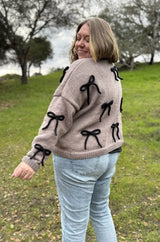 Side view of cardigan showing shoulder seam and two bows on sleeves.  thumbnail