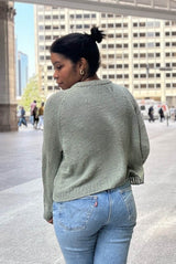 Back view of knit sweater in pale green, showing raglan lines and ribbed collar and hem.  thumbnail