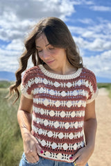 Cropped front view of crochet top, showing open stitch pattern. It has stripes of russet and open stitch pattern stripes of cream, with a diamond motif. The neck and armhole trim is also cream.  thumbnail