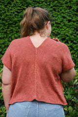Back view of knit top in red-orange, showing seam down back panels.  thumbnail