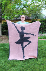 Woman holds blanket up in backyard. The afghan covers her from shoulders to feet.  thumbnail