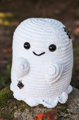 Crochet ghost stuffie, with short arms and a ruffled bottom edge. It was large black plastic eyes and an embroidered smile. thumbnail