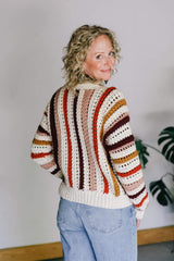 Back view of crochet cardigan, showing vertical stripes in cream, red-orange, pale peachy orange, dark red, and golden yellow. The lower hem is all in cream. thumbnail