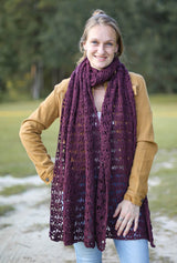 Cropped front view of woman wearing crochet stole wrapped like a scarf. It's wrapped once around her neck and hangs to mid-thigh. thumbnail