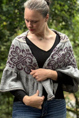 Front view of woman wearing semi-circular shawl wrapped around her shoulders. thumbnail