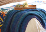 Wider view of blanket draped over corner of bed. thumbnail