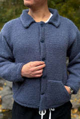 Front view of knit jacket buttoned in the front. It's made in a denim blue and has two angled front pockets. thumbnail