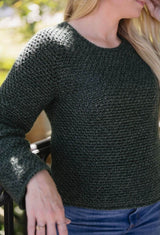 Close up side front view of crochet sweater showing textured stitch pattern on green yarn. thumbnail