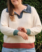 Cropped front view of knit polo sweater, with woman showing off contrast cuffs. thumbnail