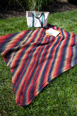 multicolor afghan on the grass with a tote bag and notebook thumbnail