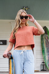 woman wearing knit tee holding skateboard thumbnail