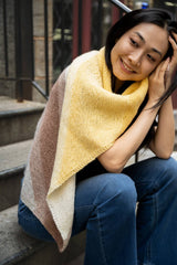 Smiling woman wrapped in knit blanket thumbnail