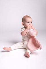 Baby holding pink crocheted bunny lovey thumbnail
