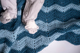 baby feet on crochet ripple blanket in contrasting blue tones thumbnail