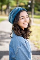person wearing a blue knit hat denim jacket and white shirt outdoors thumbnail